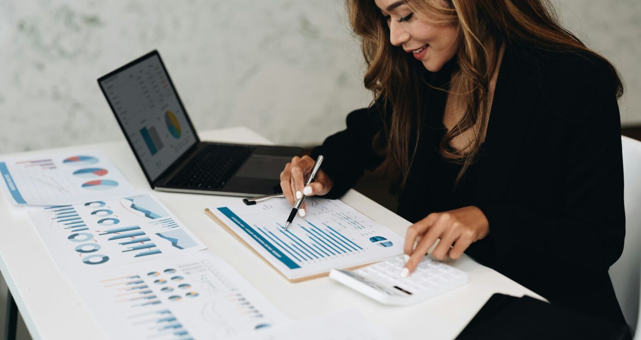 usiness analyzing investment charts with calculator laptop. Accounting and technology in office