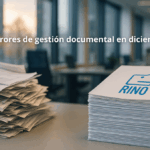Oficina corporativa en cierre de año donde documentos desordenados pasan a un sistema organizado, representando los errores de gestión documental en diciembre y su solución con RINO.